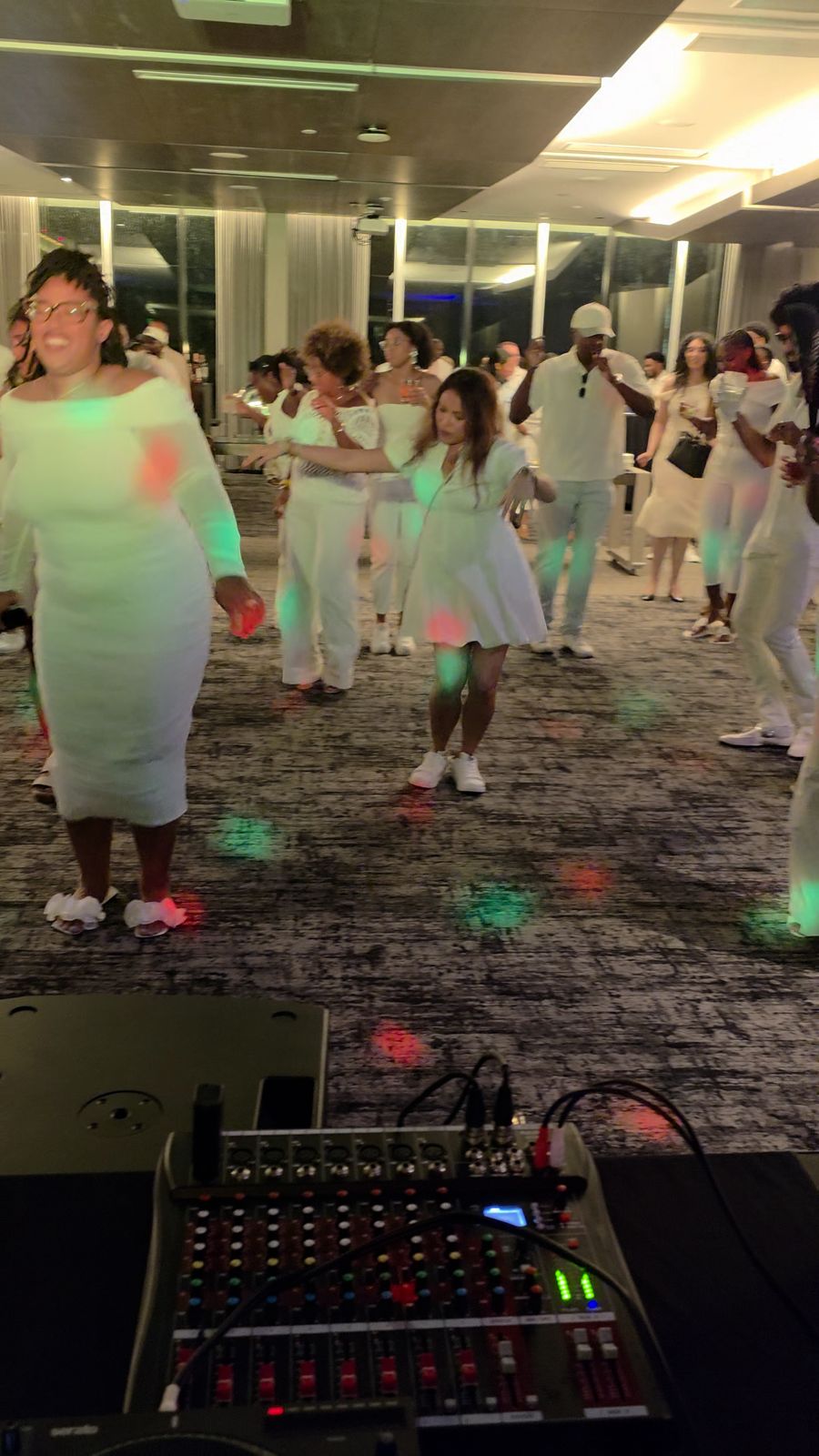 Guests dancing at a corporate all-white event with DJ Sir Uso on the decks